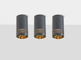 three black and gold lamps on a white surface