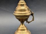 an antique brass incense burner with a cross on the top