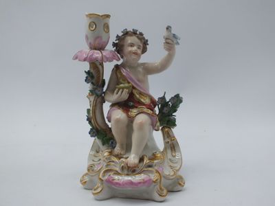 une figurine représentant un Cupidon tenant une fleur et un oiseau