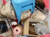 un tabouret bleu posé sur une pile d'objets divers