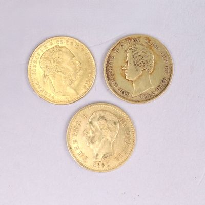 three different types of gold coins sitting on top of a white surface