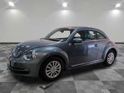 a picture of a gray volkswagen beetle parked in a garage
