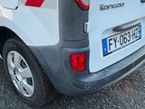 une camionnette blanche avec des bandes rouges et blanches garée dans un parking