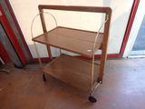 a wooden cart with a shelf on it in front of a door