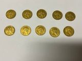 a bunch of gold coins sitting on top of a white table