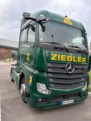 un camion vert garé sur un parking