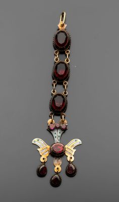 un gros plan sur un collier composé d'or et de grenats