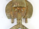 une image représentant un objet métallique sur lequel figure un visage