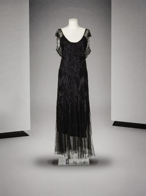 une robe noire posée sur un mannequin dans une pièce vide