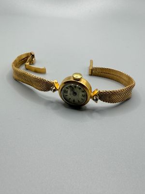 l'image d'une montre-bracelet en or entourée d'une chaîne