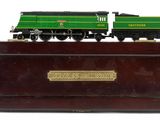 a green and black train engine on a wooden stand