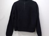 a close up of a black sweater hanging on a white wall
