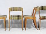 trois chaises en bois assises l'une à côté de l'autre sur une surface blanche