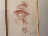 painting of a woman in a hat and dress in a gold frame