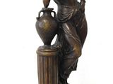bronze statue of a woman with a vase on a pedestal
