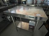 une grande table en acier inoxydable au milieu d'une cuisine