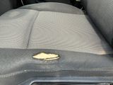 a dirty seat in the back of a car with a small piece of wood sticking out of it