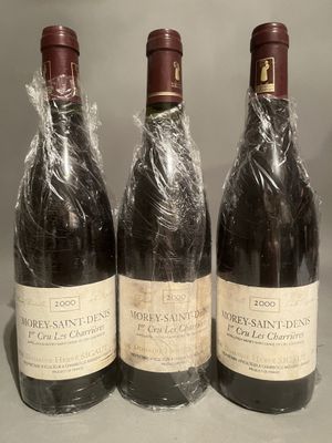 three bottles of wine wrapped in plastic sitting on a counter