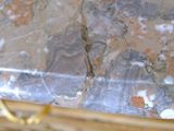 a close up of a marble table with a gold chain around it