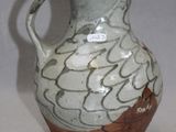 a white and brown vase sitting on a table