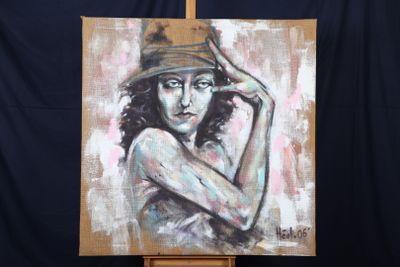 un tableau représentant une femme coiffée d'un chapeau, posé sur un chevalet