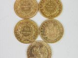 six types différents de pièces d'or sur une surface blanche