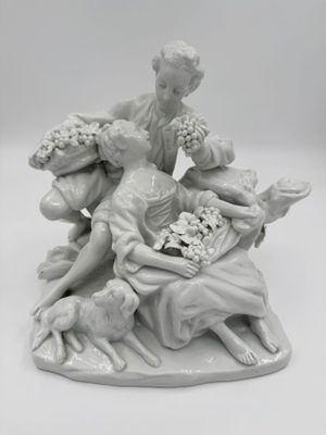 une figurine représentant une femme assise sur un lit avec des chiens