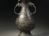 un grand vase en métal surmonté d'un oiseau