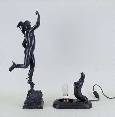 une image représentant une statue de femme tenant une lampe à côté d'un chat