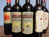 several bottles of wine are lined up on a wooden table