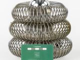 a stack of metal coils with a green card in front of them