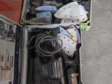 une boîte à outils contenant des outils, posée sur le sol