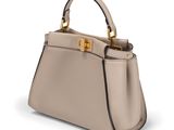 a beige leather handbag with a gold handle