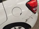 a white car with a hole in the side of it