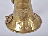 a brass bell that is on a white surface