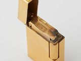 a gold lighter that is sitting on a white surface
