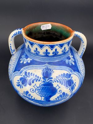 un vase bleu et blanc posé sur une surface noire