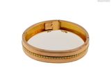 une image d'un gros plan d'un bracelet en or sur un fond blanc
