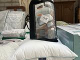 a pile of pillows and a bag on top of it