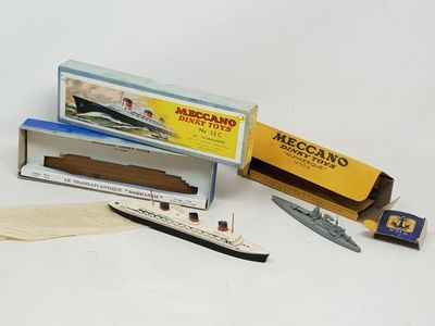 un bateau miniature et une boîte d'allumettes posés sur une surface blanche