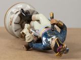 a figurine of a man laying on a table