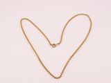 un collier en or avec un pendentif en forme de cœur sur fond blanc