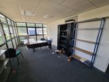 a room with a desk, shelves, and a chair in it