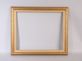 un cadre photo en or vide accroché à un mur blanc