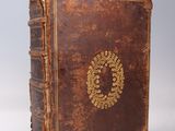 an old book with a wreath on the front of it