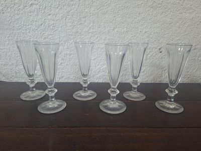 four empty wine glasses lined up on a wooden table