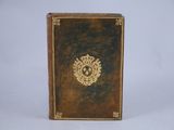 an old book with a gold emblem on the cover