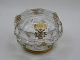 a small glass box with a gold decoration on it