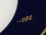 une assiette bleue et dorée ornée d'une fleur dorée