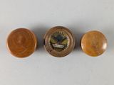 three wooden knobs and a clock on a white surface